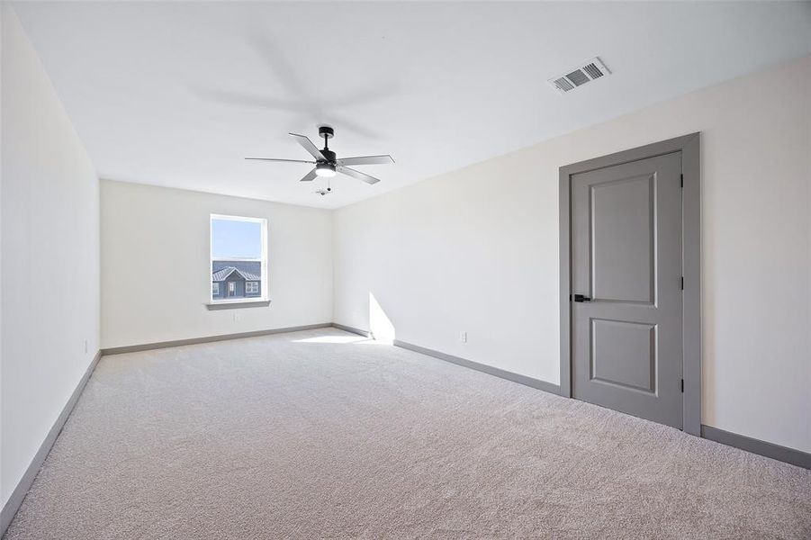 Carpeted empty room with ceiling fan