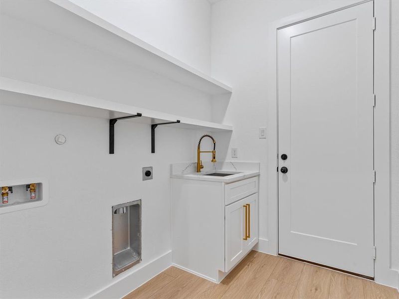 Laundry area featuring washer hookup, light hardwood / wood-style floors, electric dryer hookup, and sink