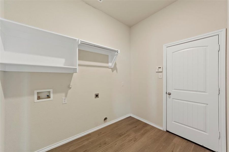 Laundry room featuring hookup for a gas dryer, electric dryer hookup, hookup for a washing machine, and hardwood / wood-style floors