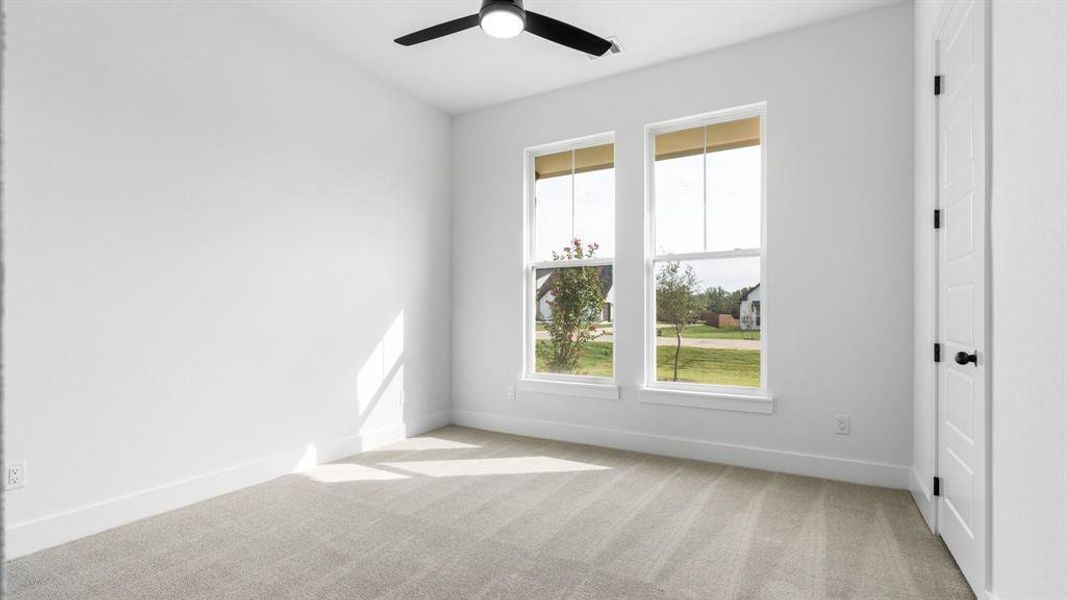 Spare room featuring ceiling fan and light carpet