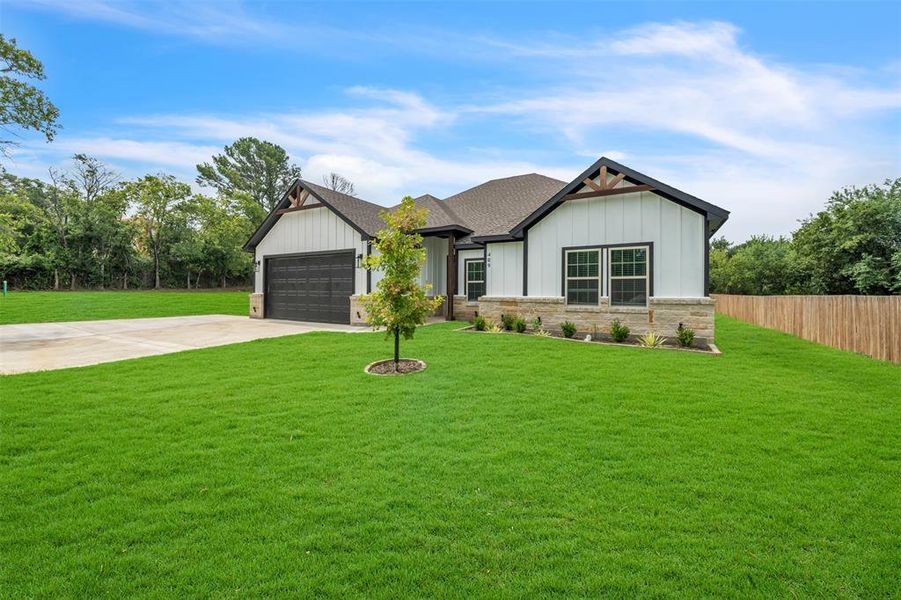 View of front of house with a garage and a front yard