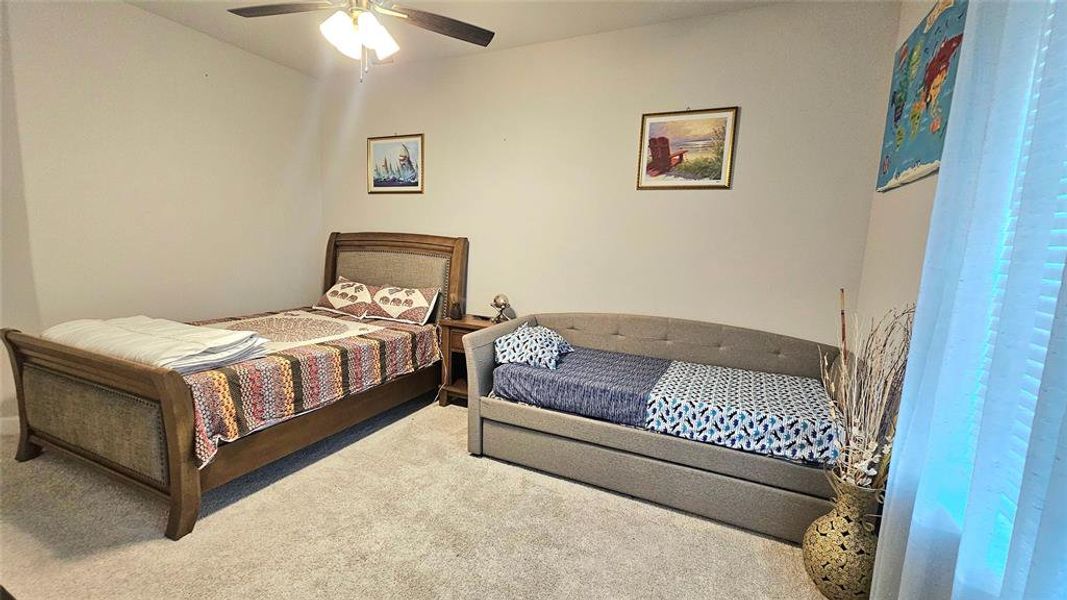 Bedroom featuring ceiling fan and carpet flooring