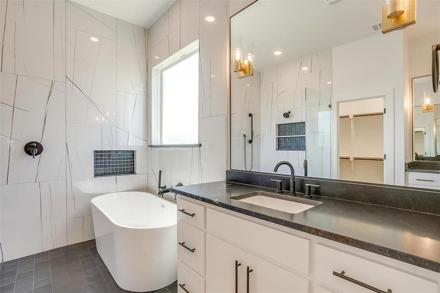 Bathroom with tile flooring, tile walls, vanity, and independent shower and bath