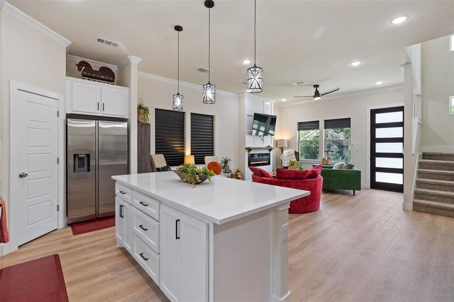 Kitchen with white cabinetry, ceiling fan, pendant lighting, light luxury vinyl flooring, and high quality fridge