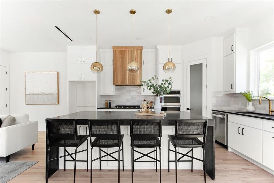Kitchen featuring a center island, white cabinets, tasteful backsplash, and stainless steel appliances
