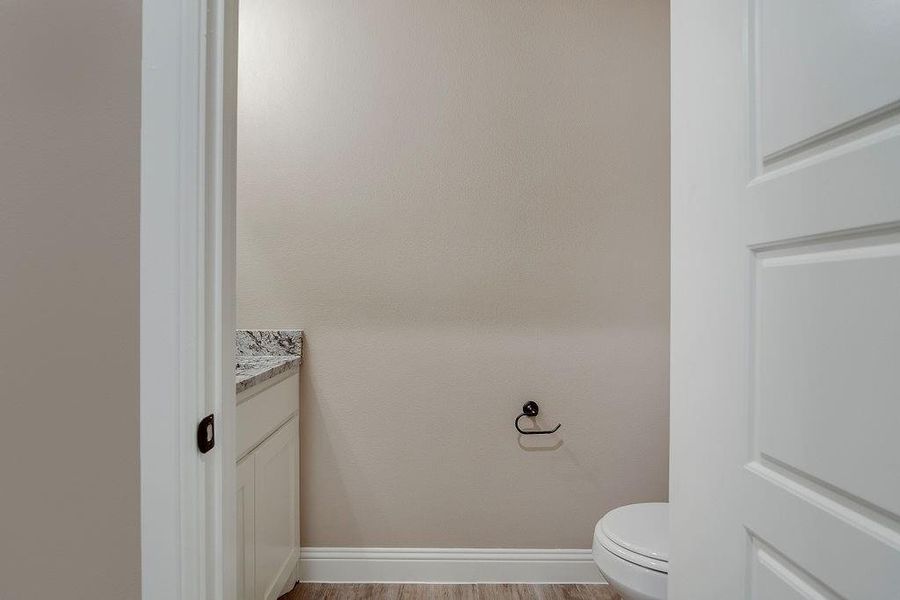 Bathroom with vanity, hardwood / wood-style flooring, and toilet