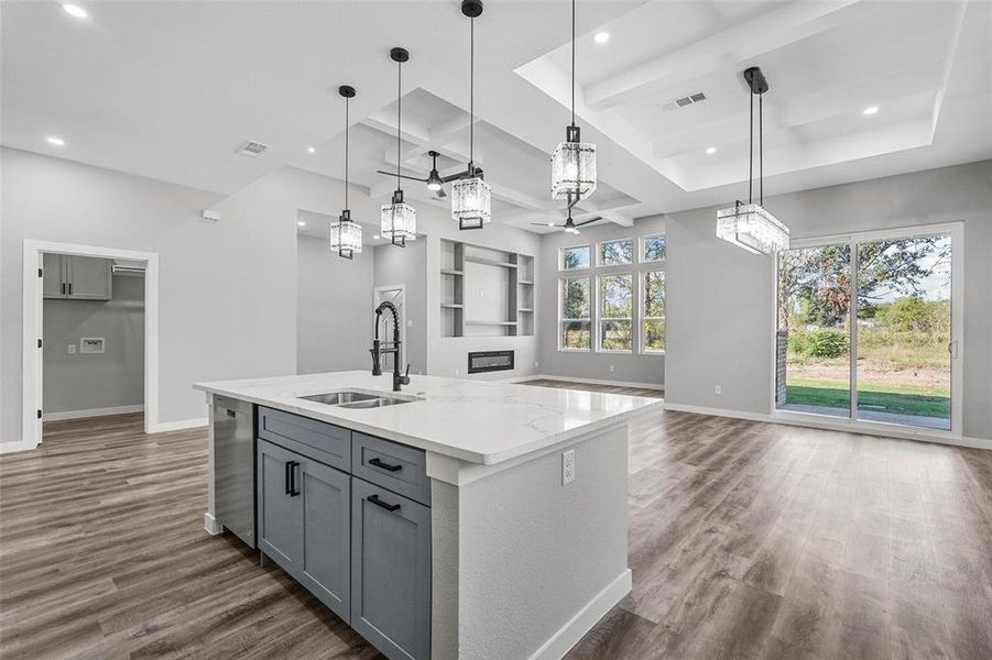 Kitchen with sink, an island with sink, gray cabinetry, pendant lighting, and dark hardwood / wood-style flooring