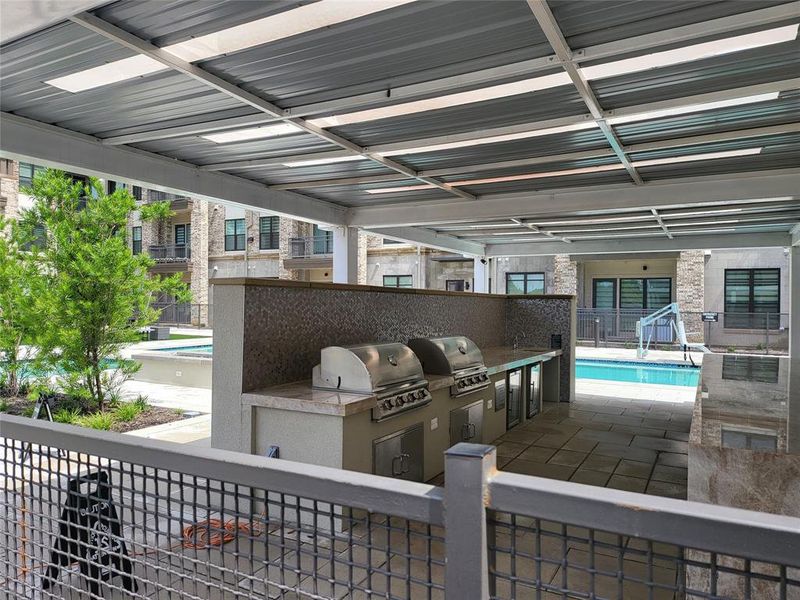 View of patio / terrace with a balcony, a grill, an outdoor kitchen, and a fenced in pool