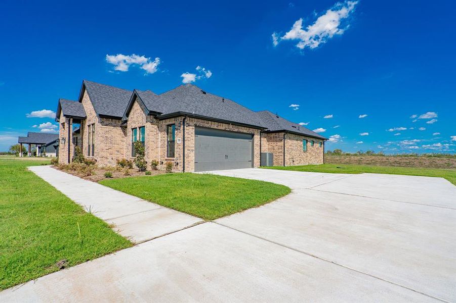 View of front of house with a garage and a front lawn