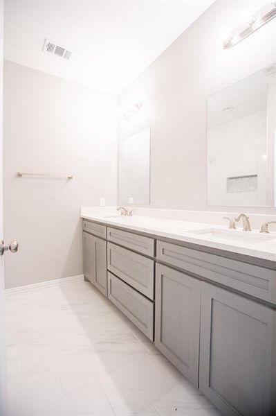 Bathroom featuring tile patterned floors and double sink vanity