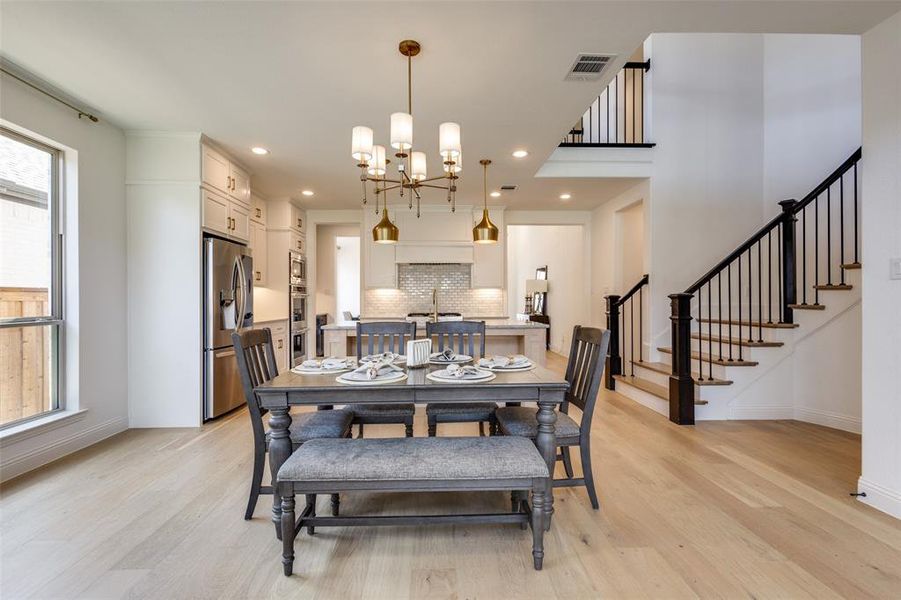 Dining space featuring sink, light hardwood / wood-style flooring, and an inviting chandelier