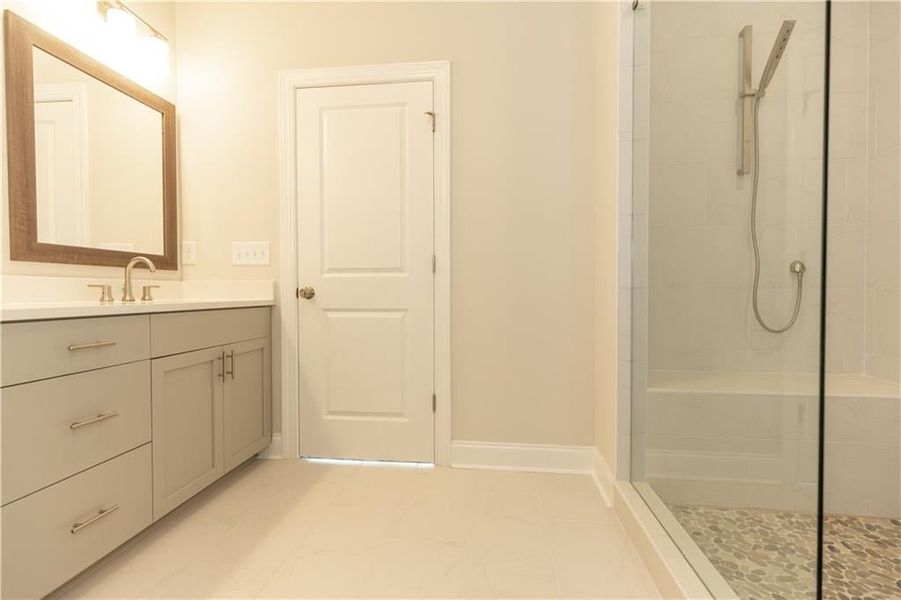 Owners bathroom with lovely 12x24 Emser tile and soft close cabinetry