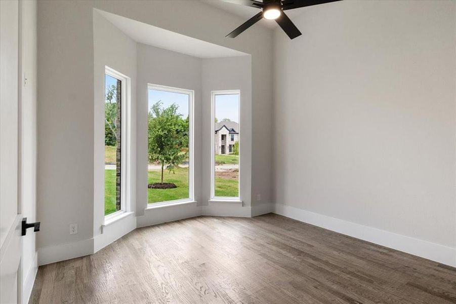 Empty room featuring ceiling fan and hardwood / wood-style floors