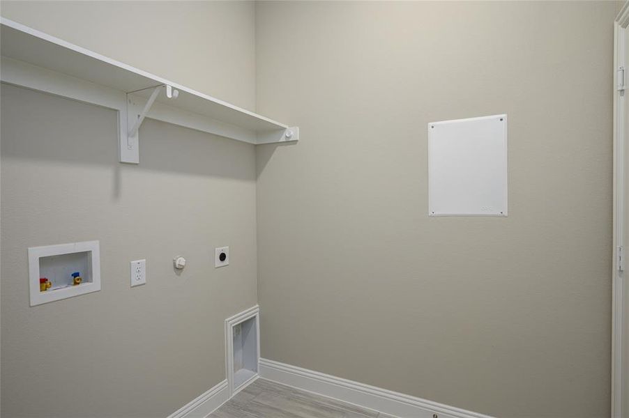 Washroom with electric dryer hookup, gas dryer hookup, hardwood / wood-style flooring, and washer hookup