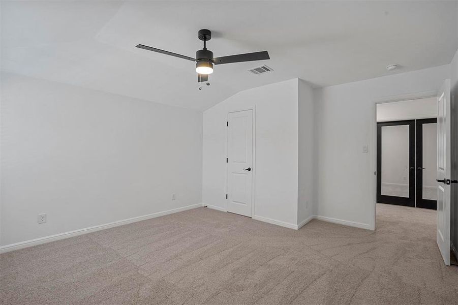 Unfurnished bedroom with lofted ceiling, light carpet, and ceiling fan