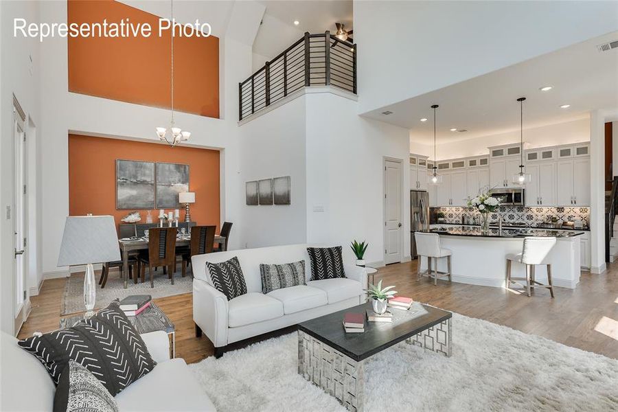 Living room featuring hardwood / wood-style flooring, a chandelier, and a high ceiling