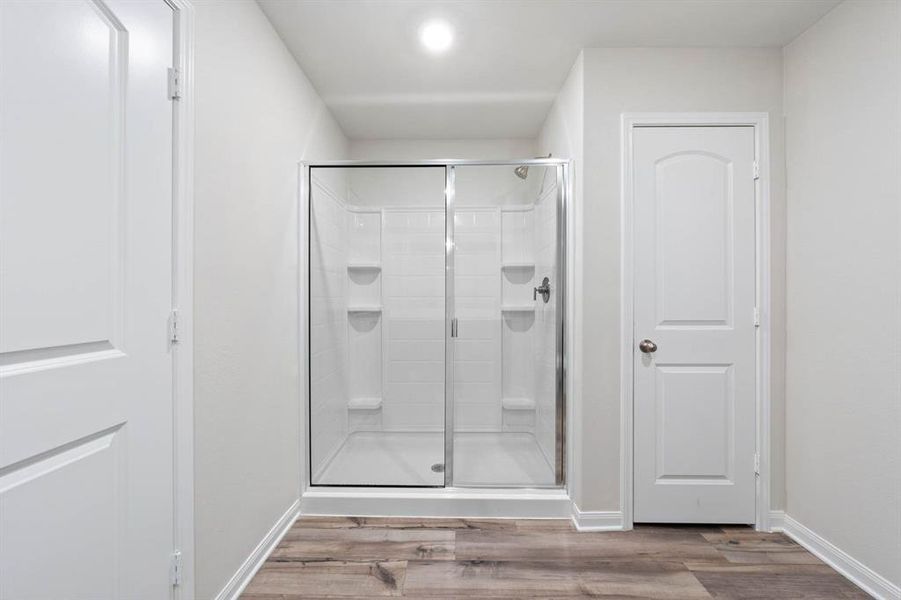 Bathroom featuring hardwood / wood-style flooring and an enclosed shower