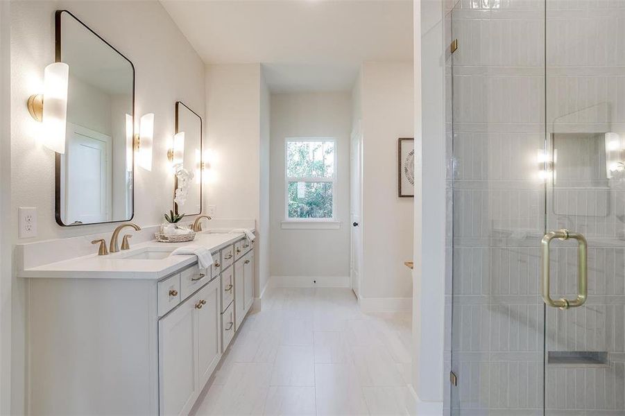 This spa-like bathroom has it all - a large walk in shower, free-standing tub, and ample storage space.