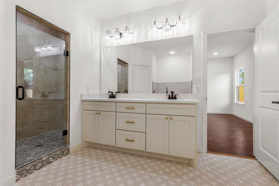 Bathroom featuring tile patterned flooring, an enclosed shower, and dual bowl vanity