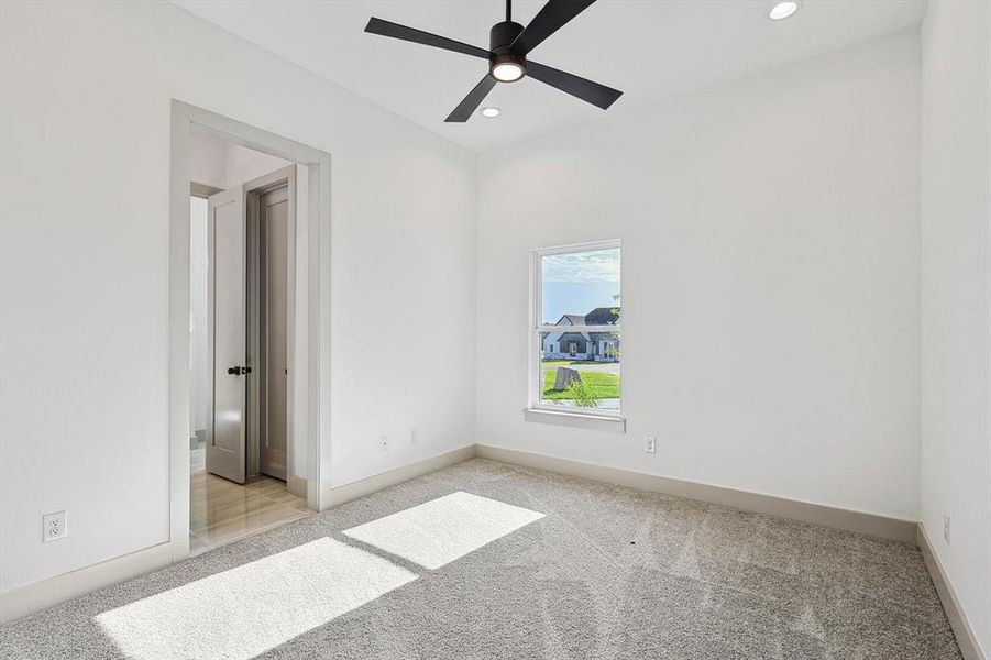 Carpeted empty room featuring ceiling fan