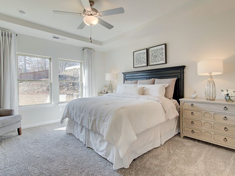 Tray ceilings add elegance to the main level primary suite.