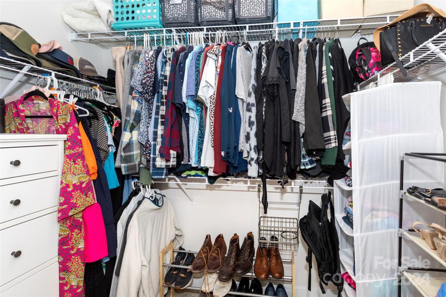 Large walk-in closet attached to primary bedroom and bathroom.