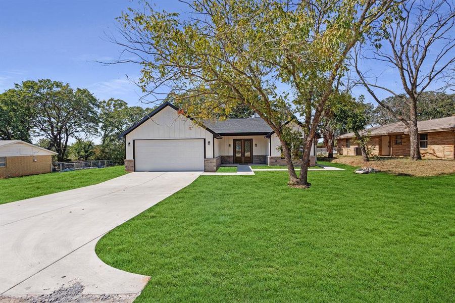 View of front of home featuring a garage and a front lawn