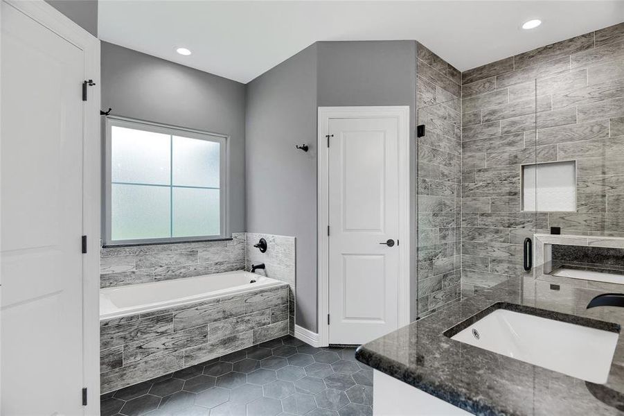 Bathroom with tile flooring, vanity, and plus walk in shower