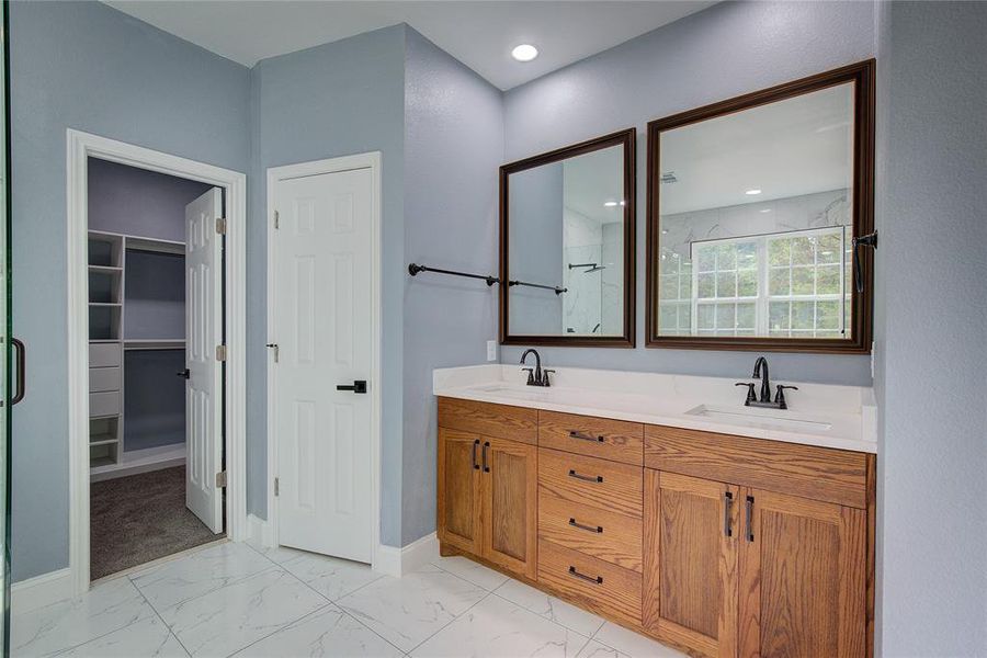 Master bathroom featuring tile patterned flooring and dual bowl vanity