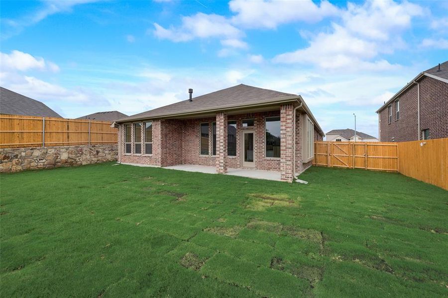 Rear view of property with a lawn and a patio area