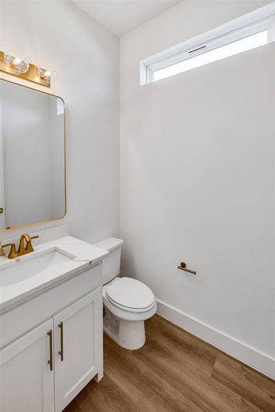 Bathroom with vanity, hardwood / wood-style floors, and toilet