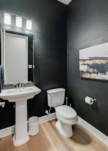 Bathroom featuring hardwood floors and toilet