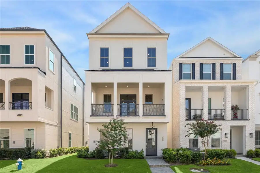 Inside the Guard Gated Houston Community inside the Loop is a 3 story Pelican Builder Built home with an Elevator shaft and outdoor living with green grass in the front of the home.