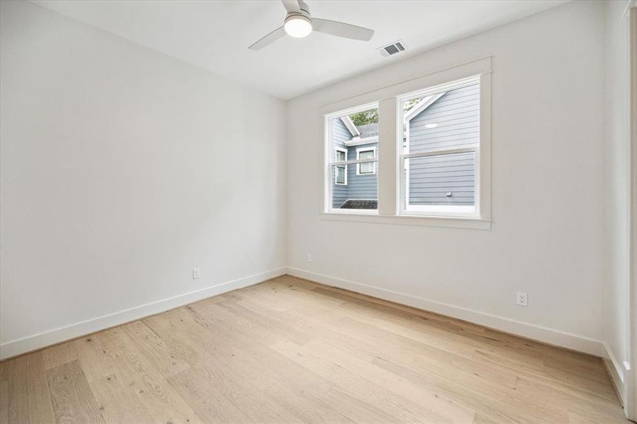 Secondary bedroom with hardwood floors and modern ceiling.