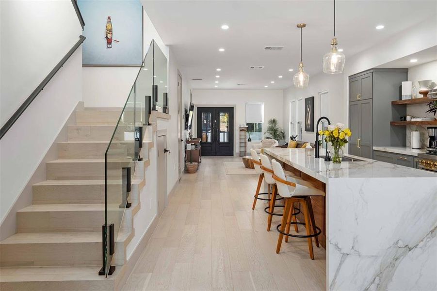 The kitchen features a center island with quartz countertops and a waterfall edge, combining durability with contemporary style.