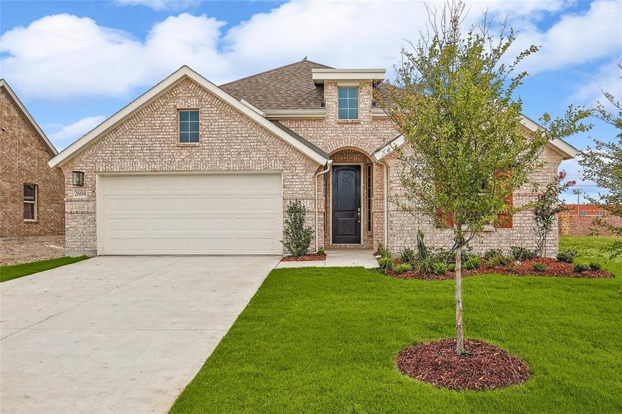 View of property featuring a garage and a front yard