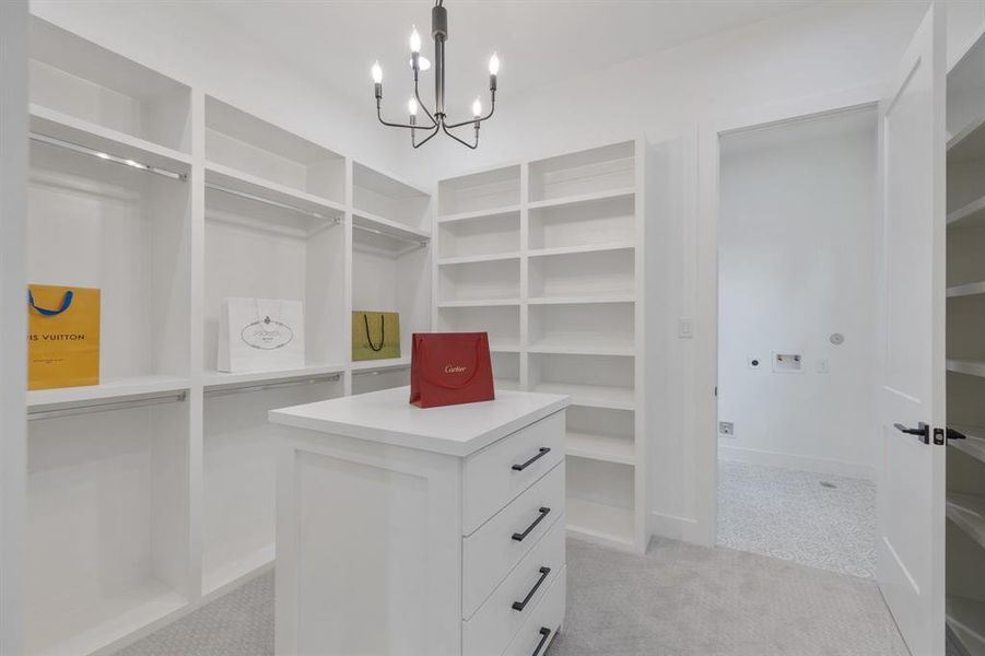 One of TWO primary closets.  This closet featues a storage island, decorative lighting and ample space for clothing and accessories.