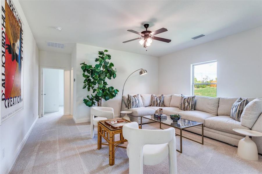 Carpeted living room with ceiling fan