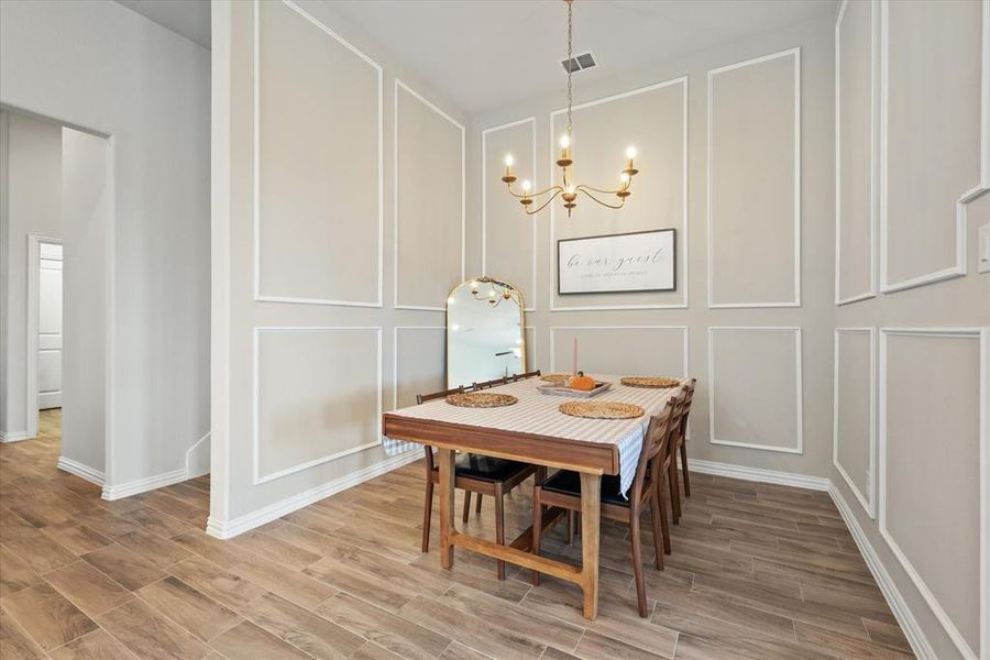 Dining area with gorgeous molding and a stunning matte gold chandelier