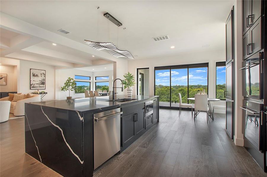 Kitchen featuring dark hardwood / wood-style floors, hanging light fixtures, a kitchen island with sink, stainless steel dishwasher, and sink