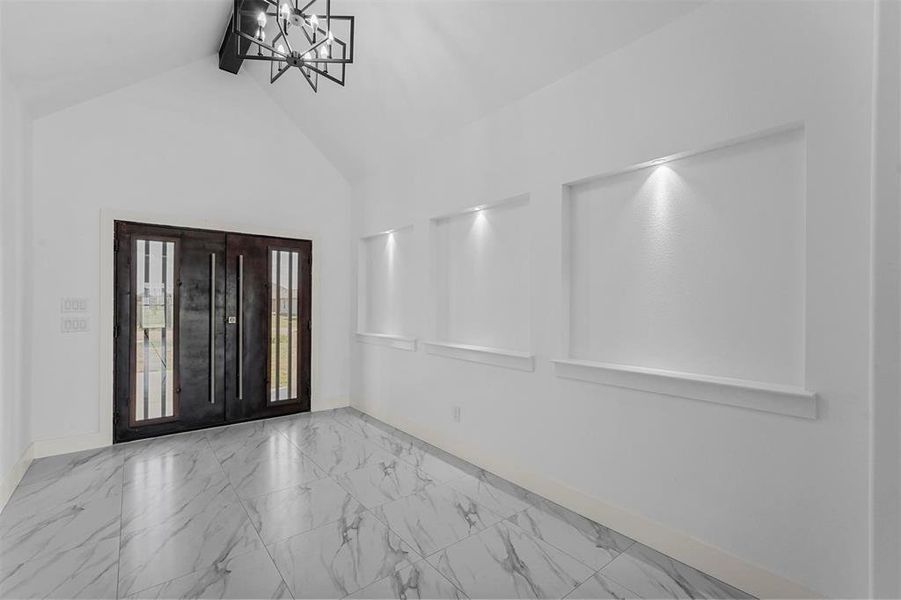 Entryway with a notable chandelier and high vaulted ceiling