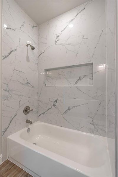 Bathroom featuring tiled shower / bath and hardwood / wood-style flooring