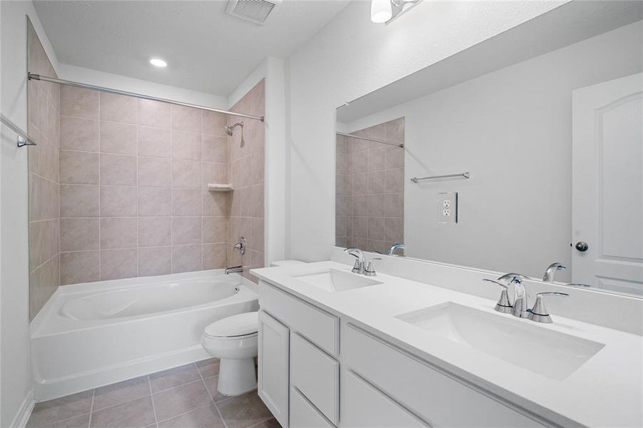 This primary bathroom is definitely move-in ready! Featuring a tub/shower combo with tile surround, stained cabinets with light countertops, tile flooring, high ceilings, custom paint, sleek and dark modern finishes.