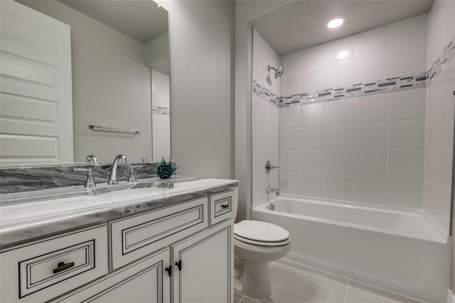 Full bathroom featuring vanity, Dolomite counters, shower-over-tub and tile floors