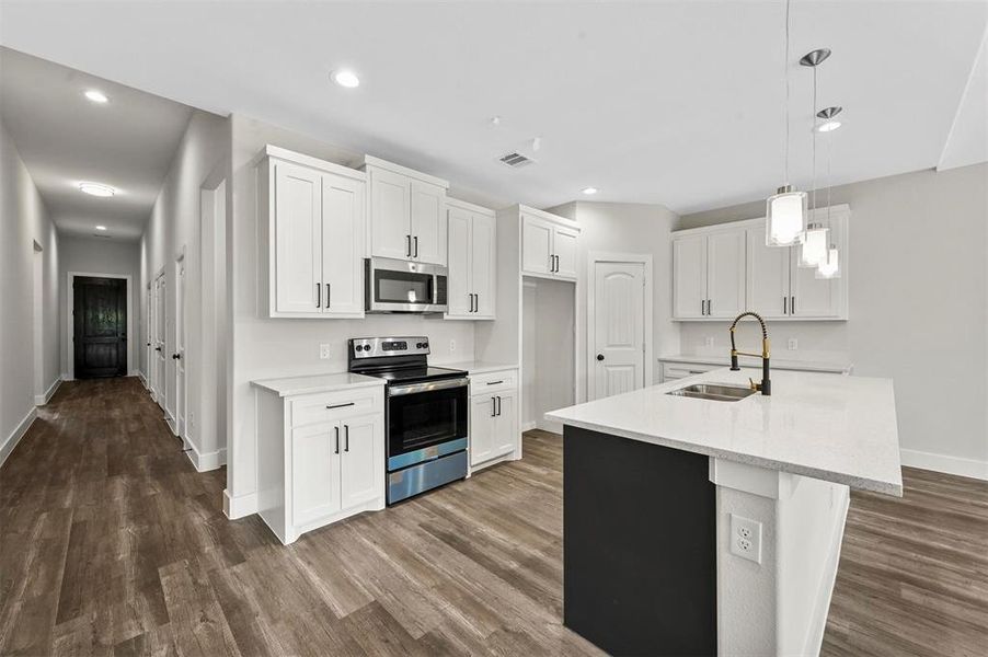 Kitchen featuring appliances with stainless steel finishes, dark hardwood / wood-style flooring, white cabinetry, and sink