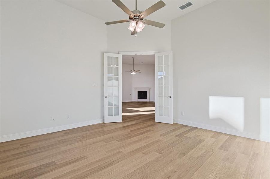 Unfurnished room with french doors, ceiling fan, high vaulted ceiling, and light hardwood / wood-style flooring