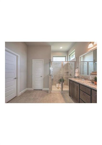 Bathroom with vanity, an enclosed shower, and tile patterned flooring