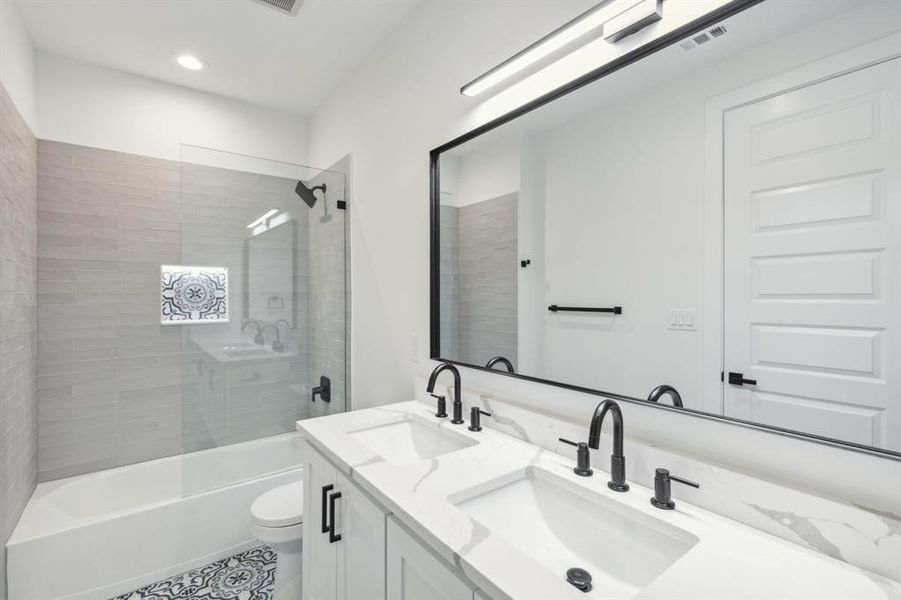 Full bathroom with vanity, tiled shower / bath combo, and toilet