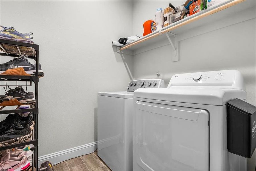 Laundry room featuring washer and clothes dryer and wood-type flooring