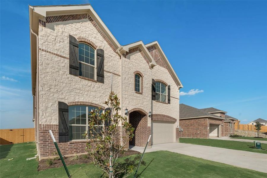 View of front of house featuring a garage and a front yard